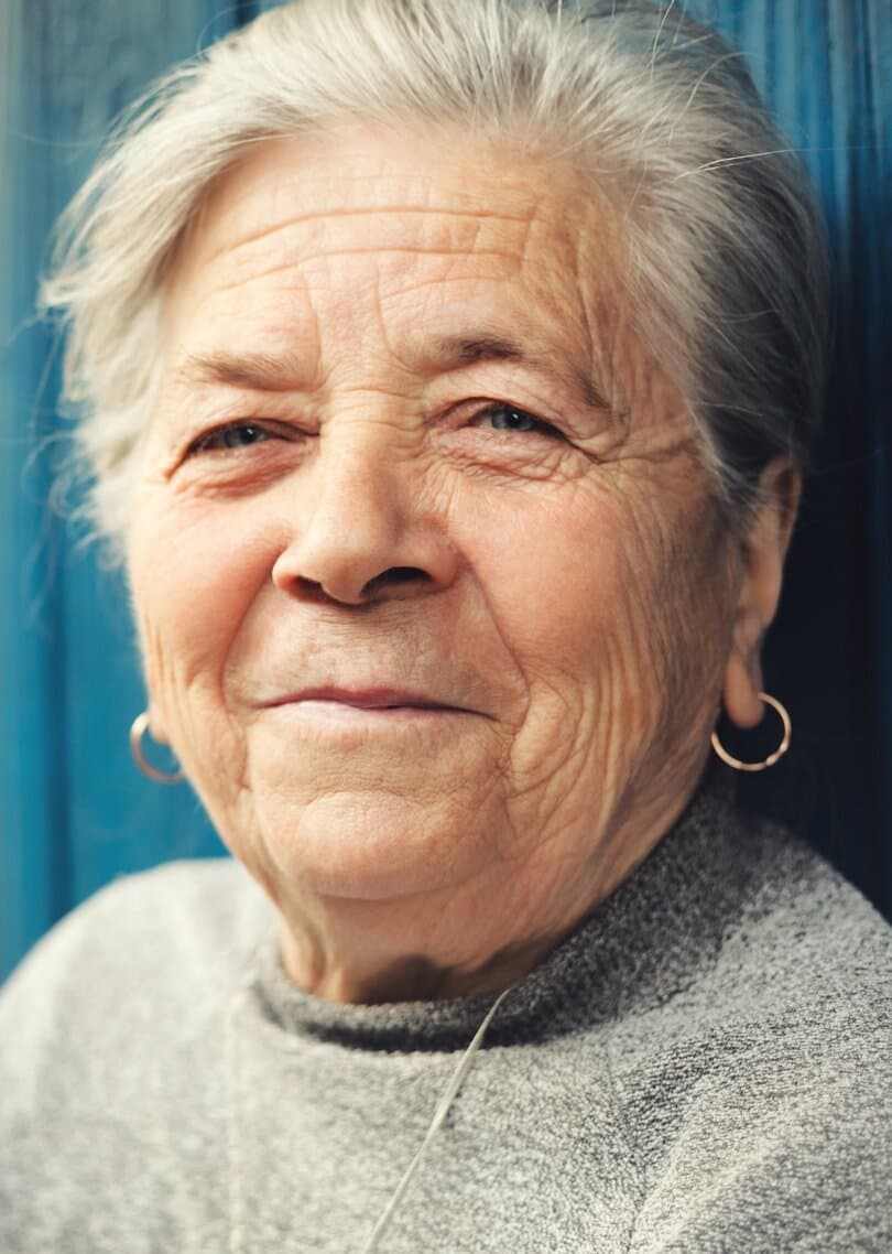 Magaly, an older woman with gray hair smiling at the camera